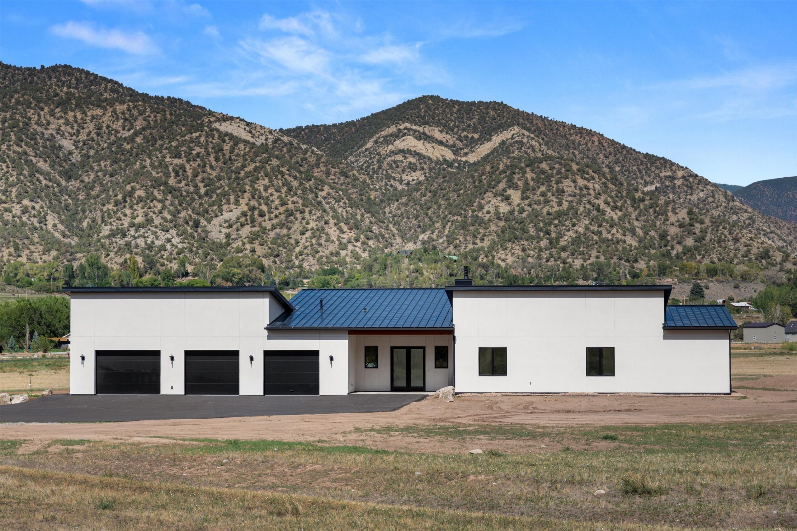 Front elevation with mountain backdrop and garage