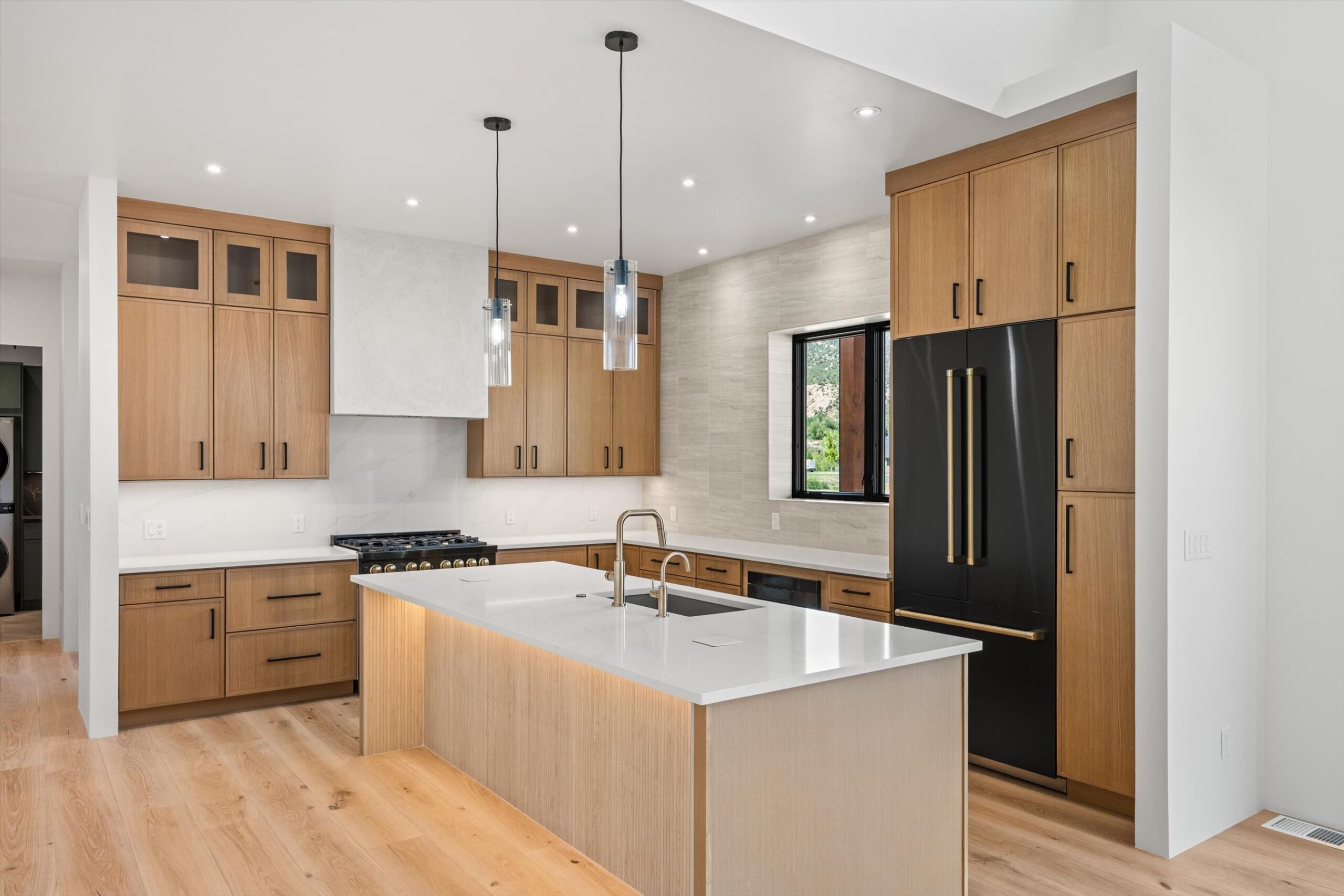 Kitchen wide view with black paneled refrigerator