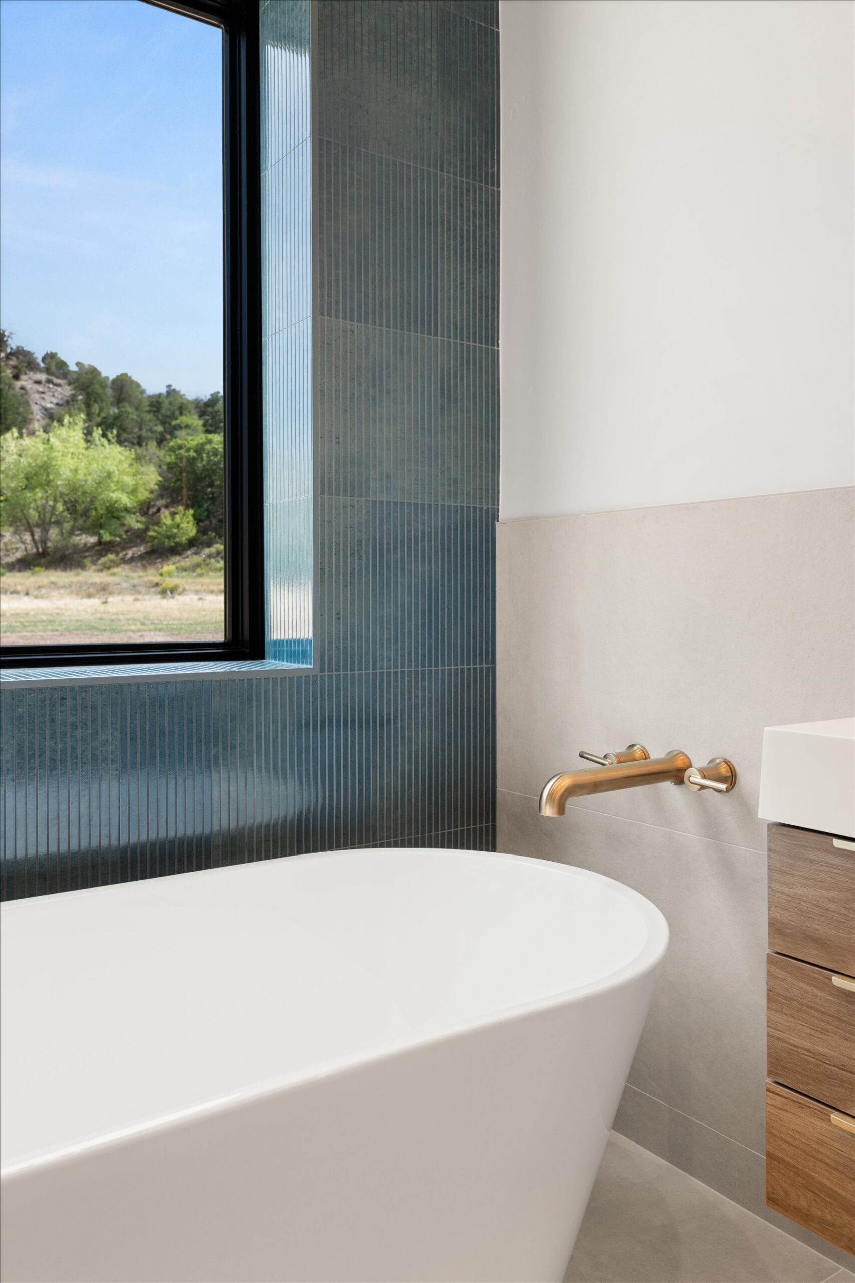 Freestanding tub with wall-mount gold fixtures