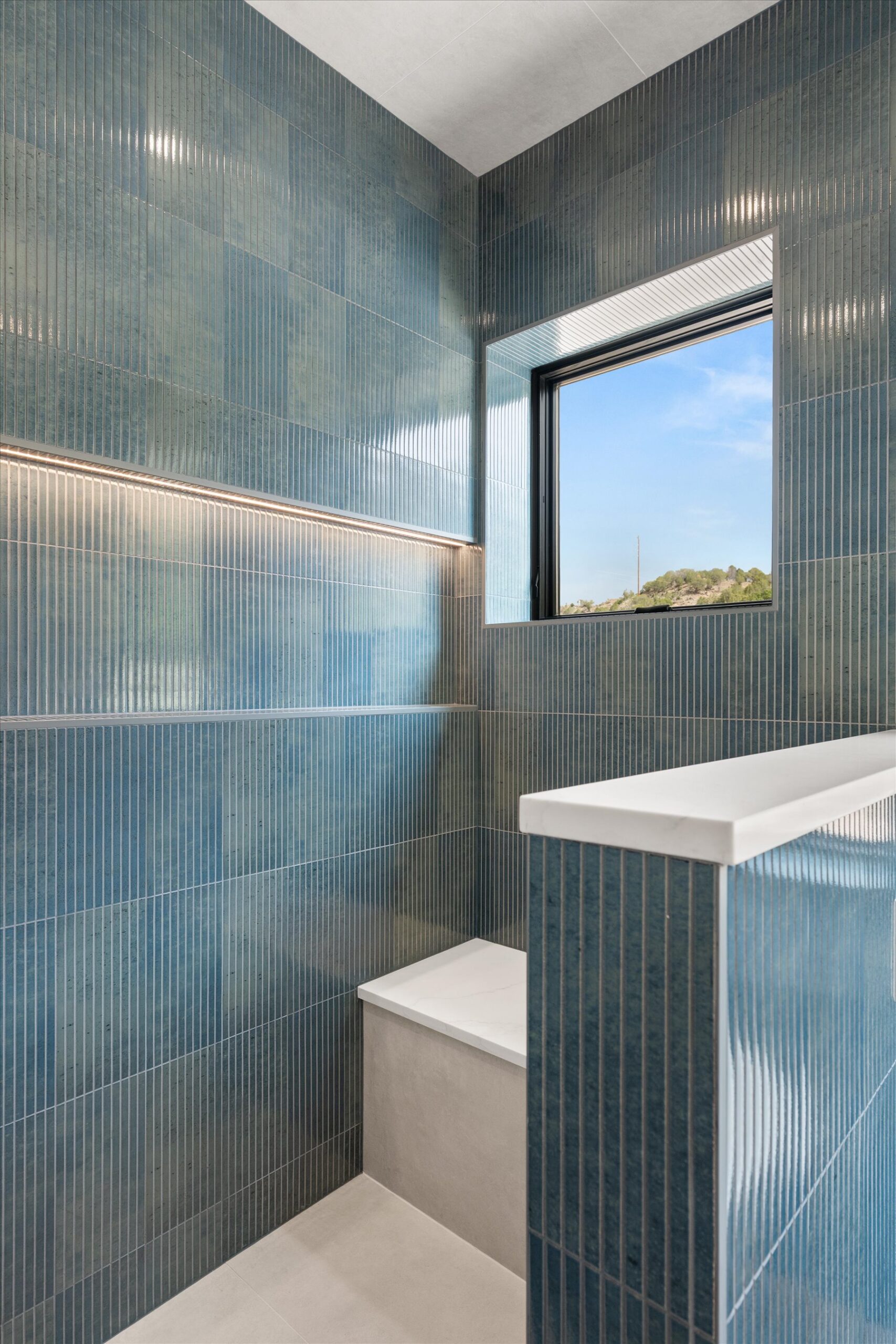 Walk-in shower corner with bench and window