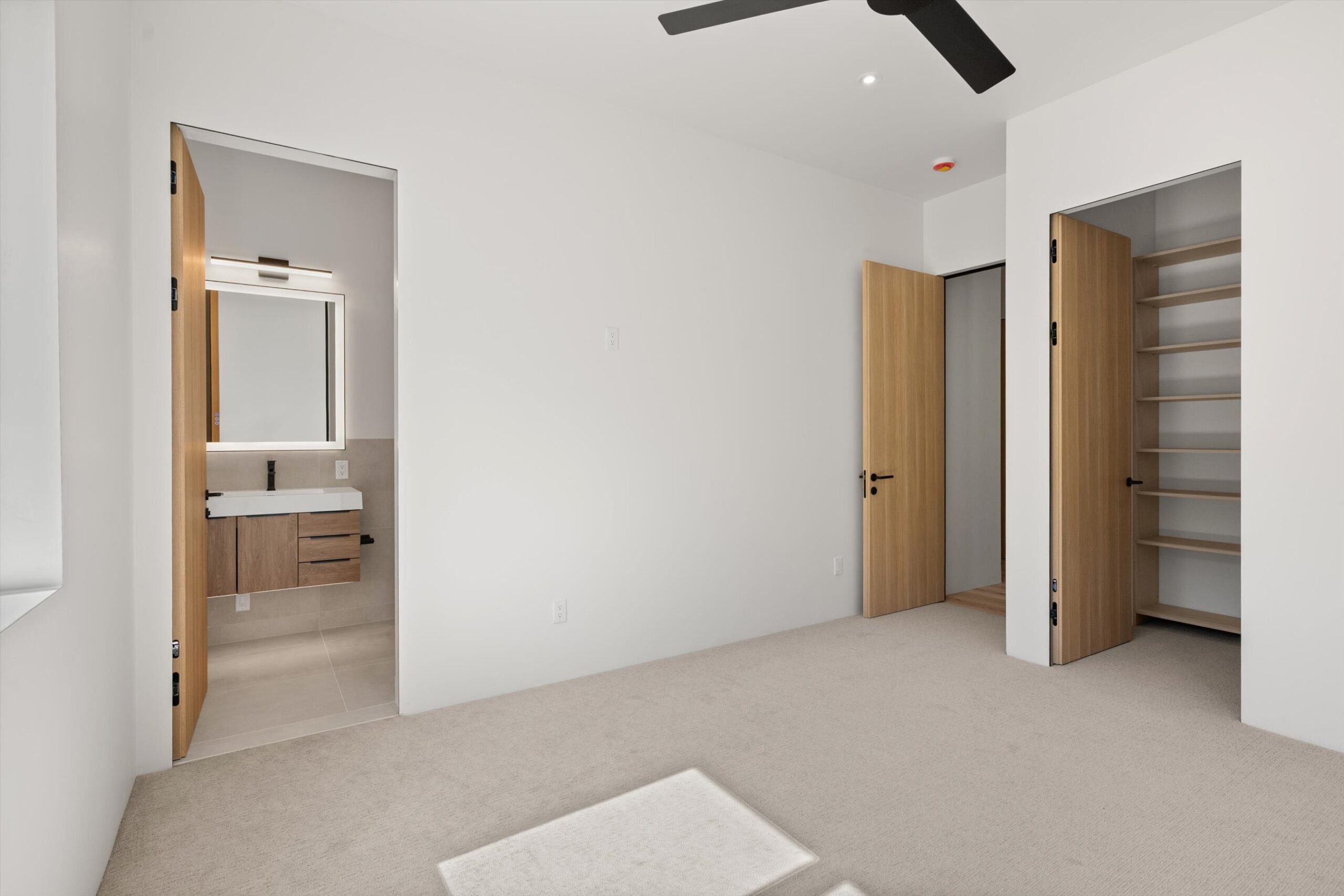 Secondary bedroom with ensuite bath and closet doors