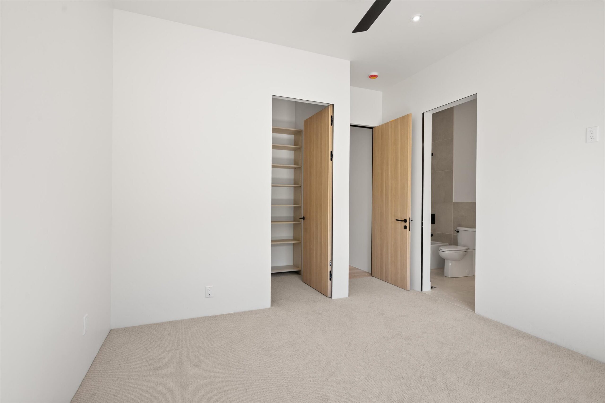Secondary bedroom with ensuite bath and closet doors